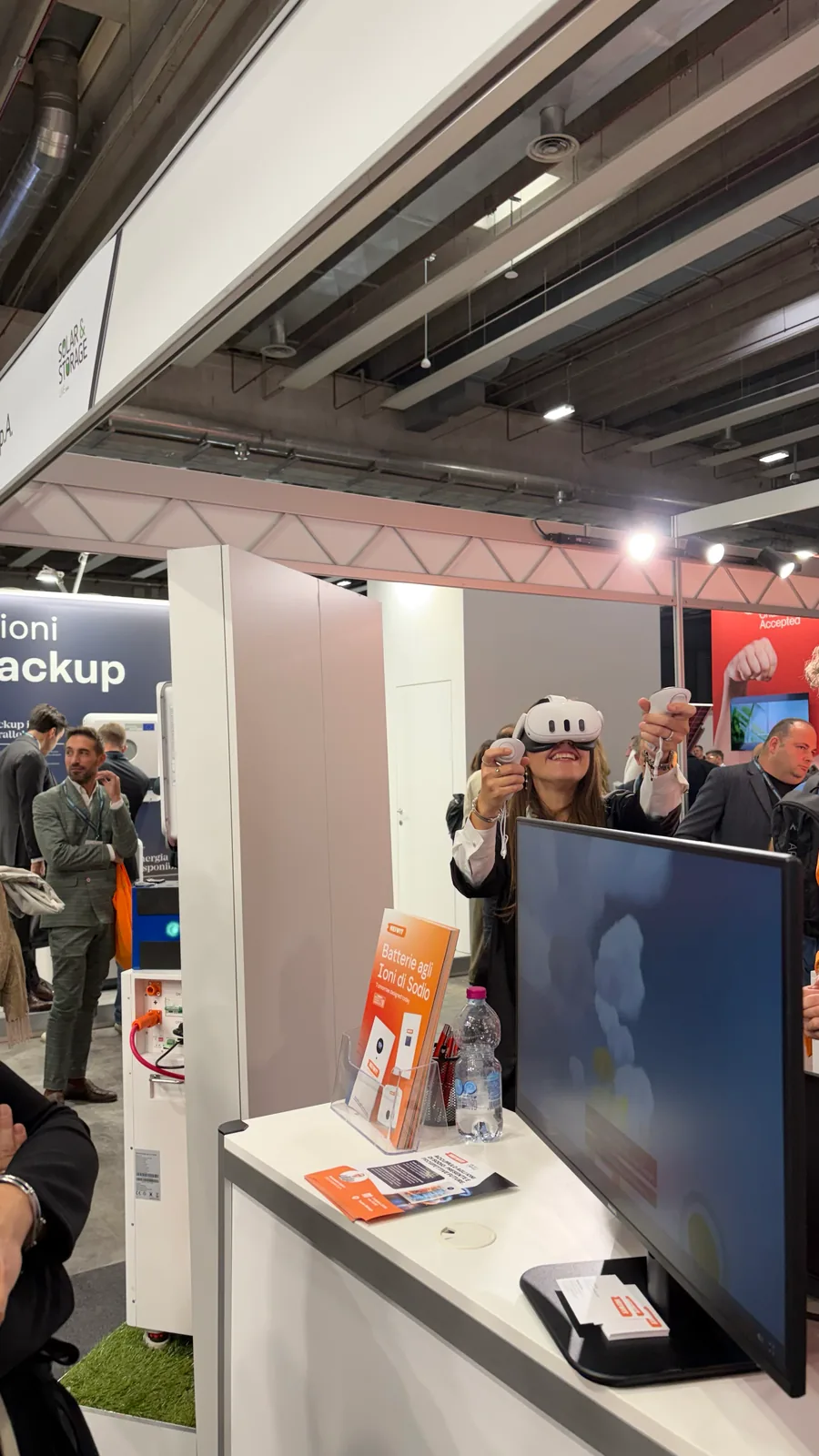 Visitatrice con visore e controller per la realtà virtuale allo stand Heiwit
